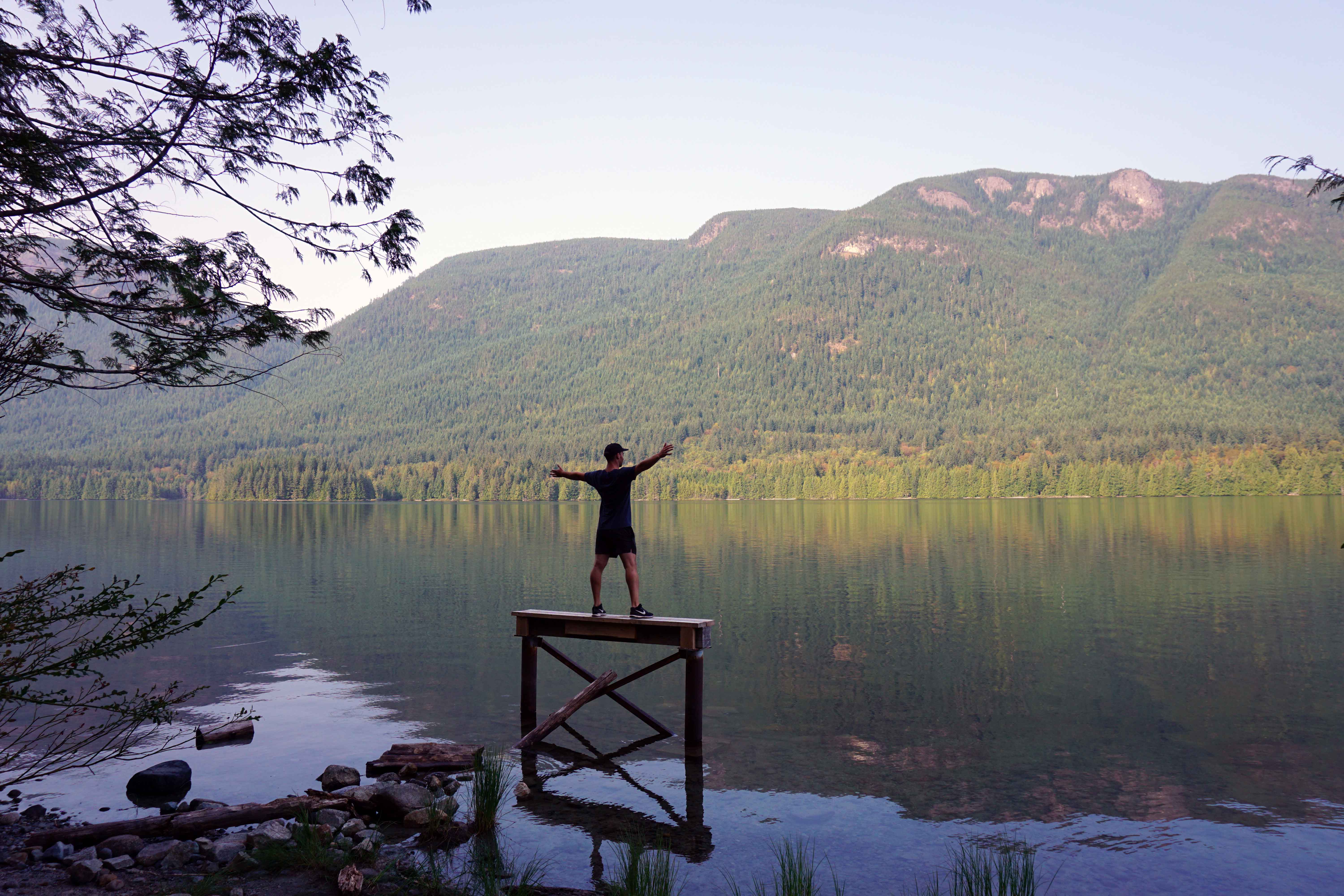 Man stands on wooden platform in lake