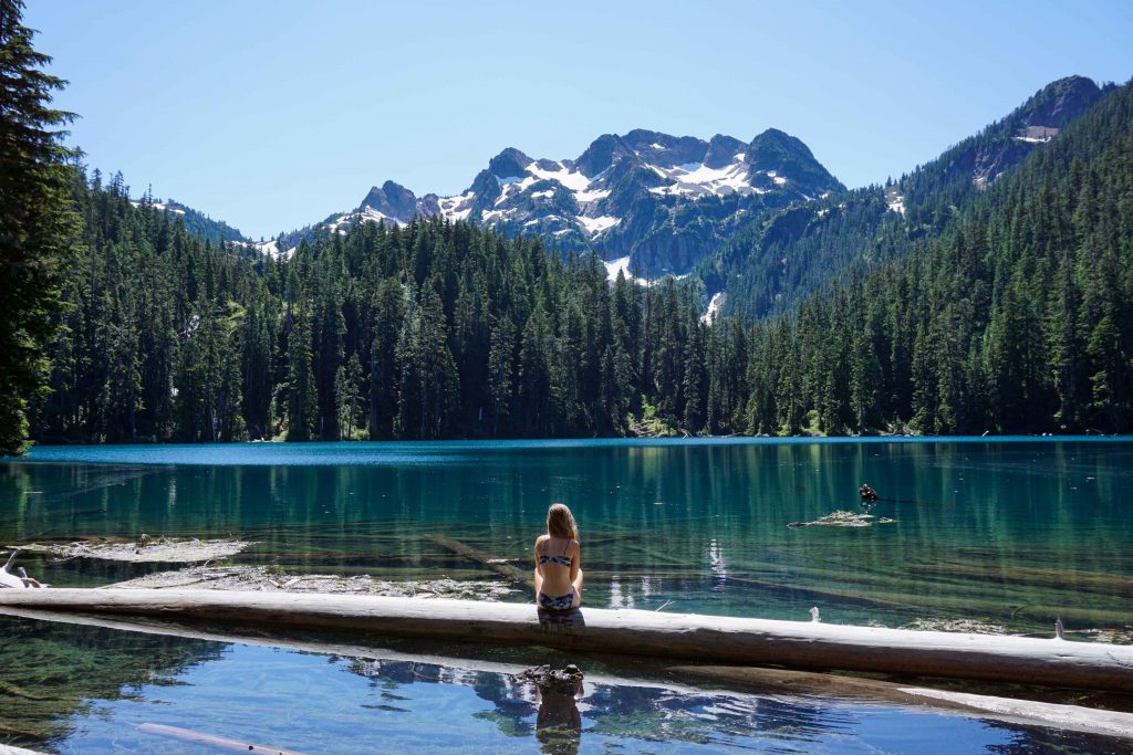 Woman looks across blue lake and Brunswick Mountain