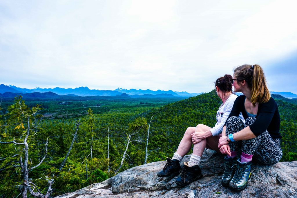 Two women look across rainforest from high vantage point