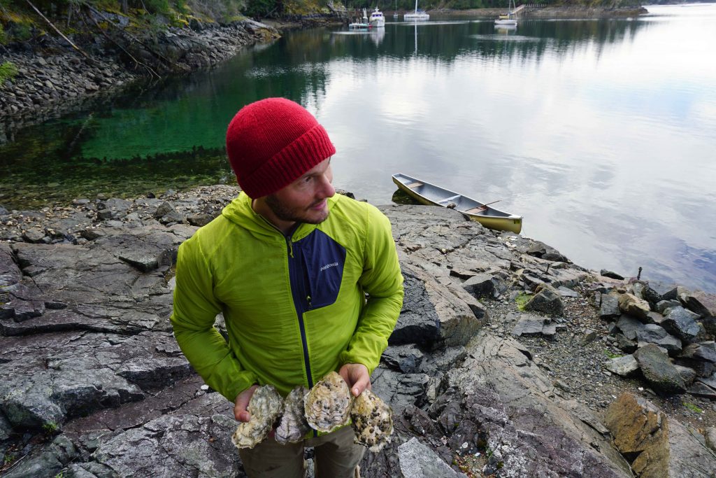 Man holds four large oysters