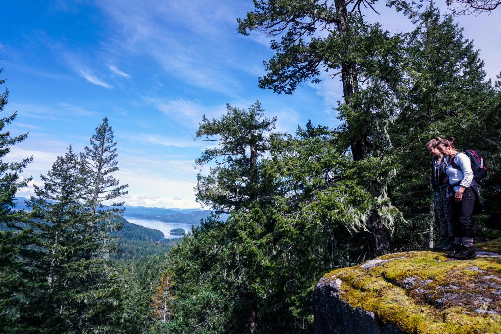 Two women stand on high elevation rock