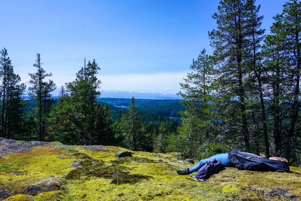 Woman sleeps on mossy rocks