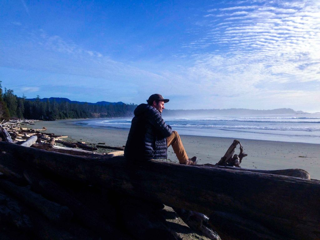 Man stares out across empty beach