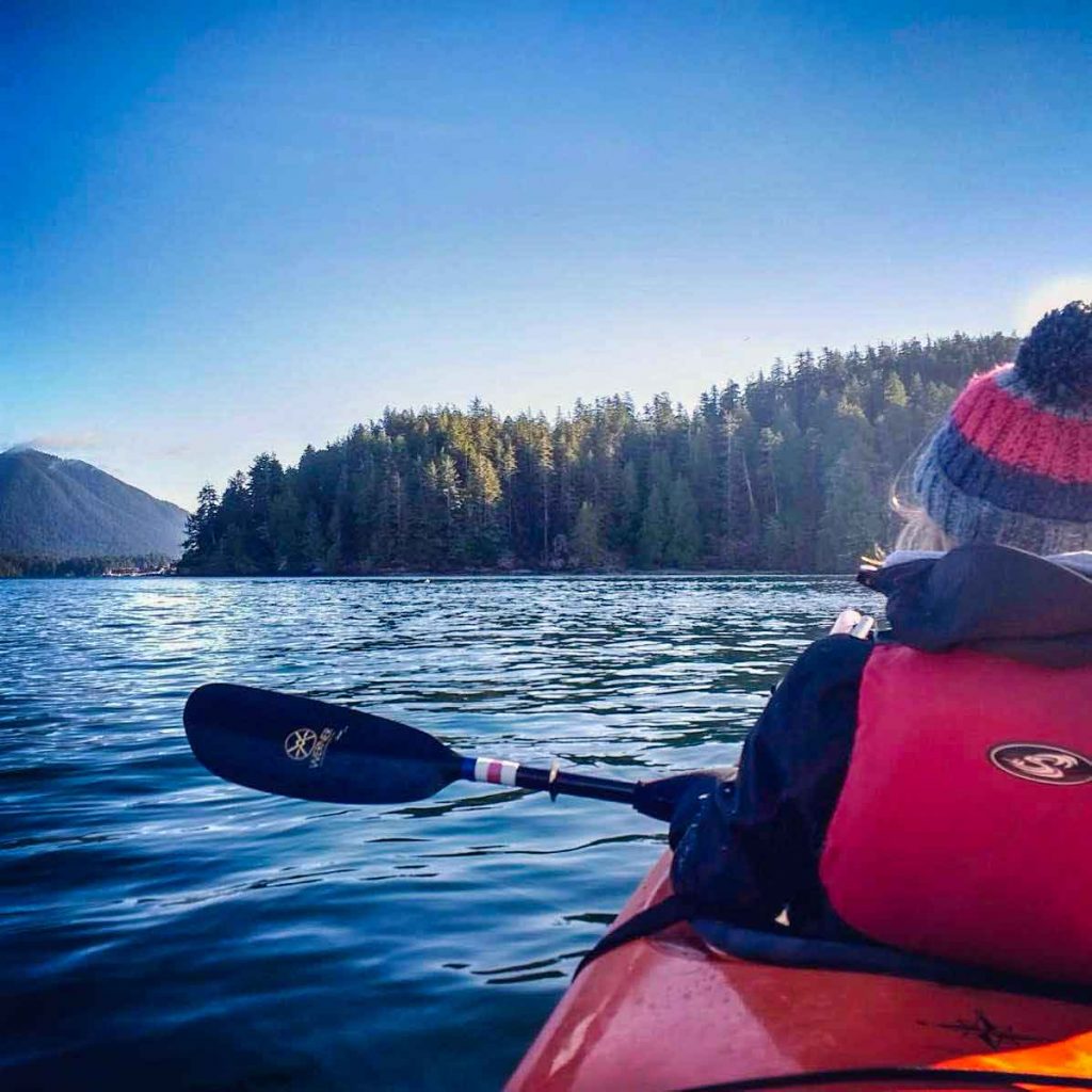 Back of woman in a red kayak on the sea