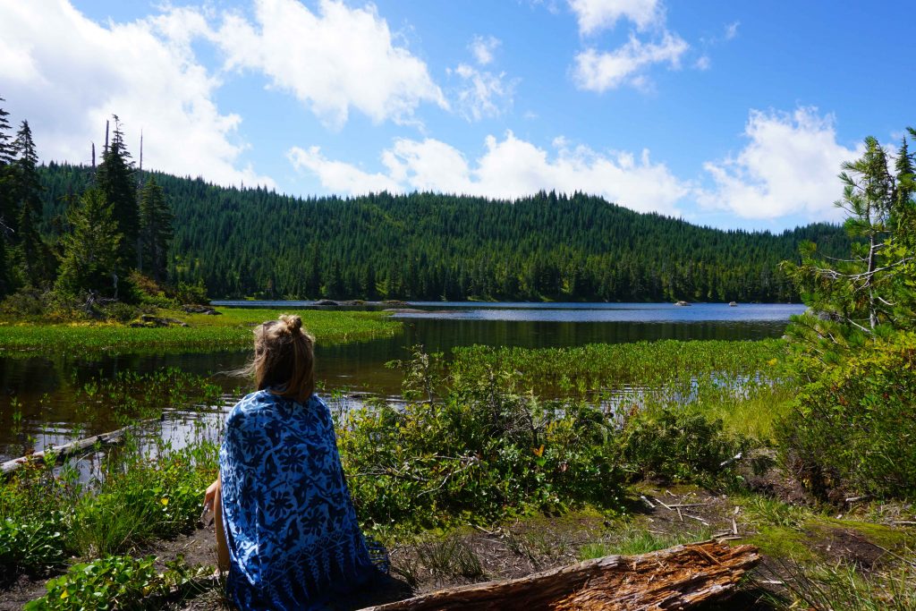 Woman sits in front of lake