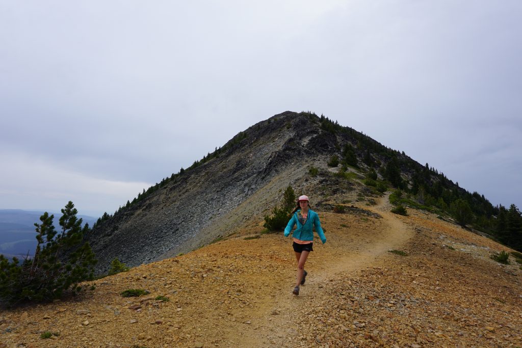 Woman runs down mountain ridge