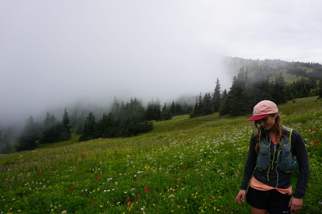 Woman stands in meadow of wildflowers