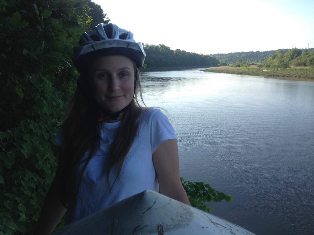 Woman in cycling helmet next to river