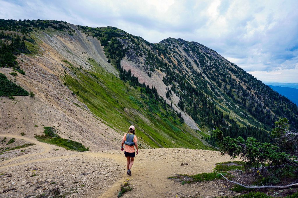 Woman runs along mountain ridge