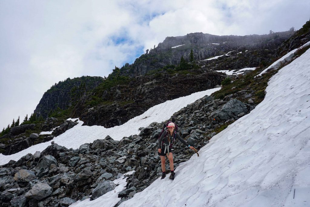 Woman traverses snowy boulder field