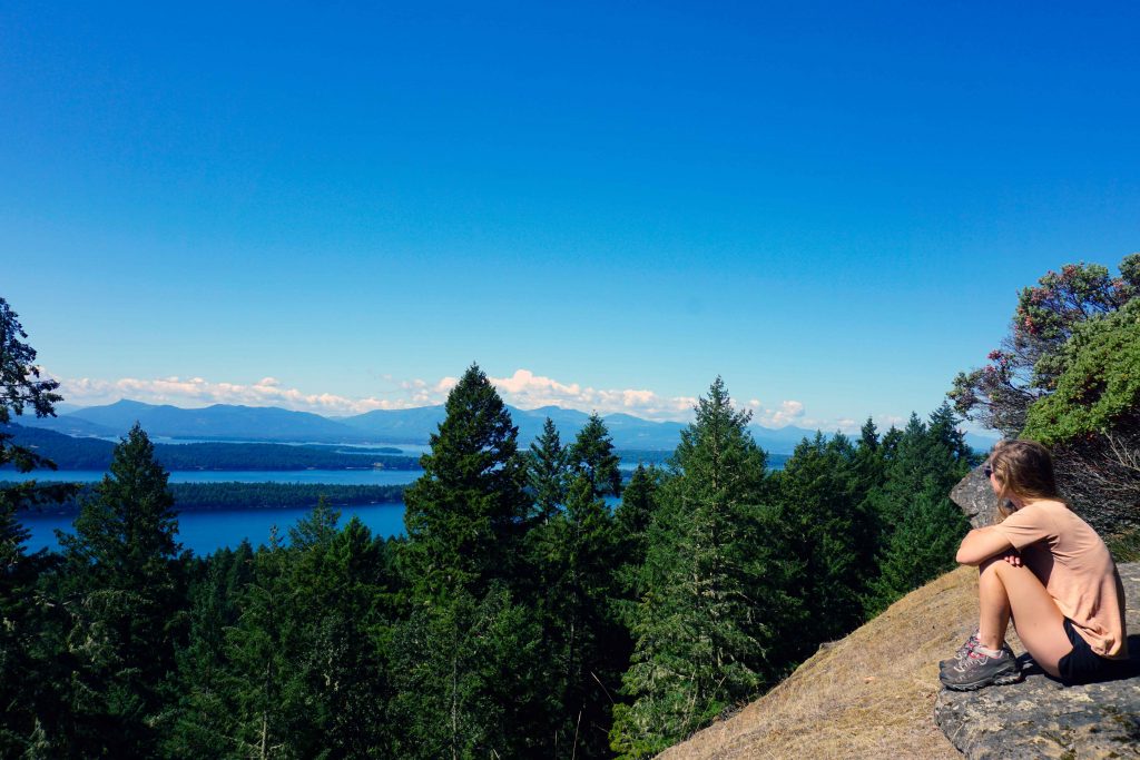 Woman looks out from ridge across the sea