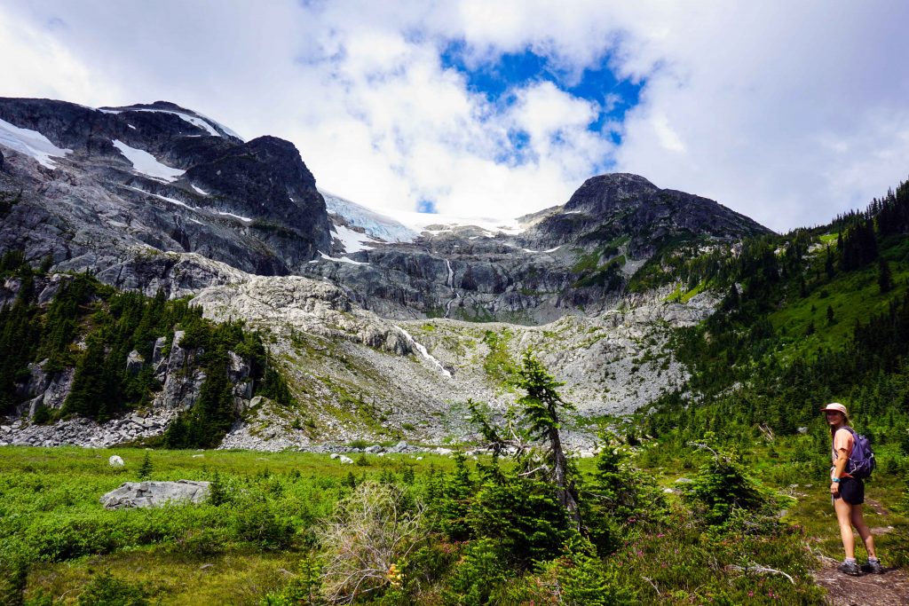 Woman hiking towards glacier in sunshine