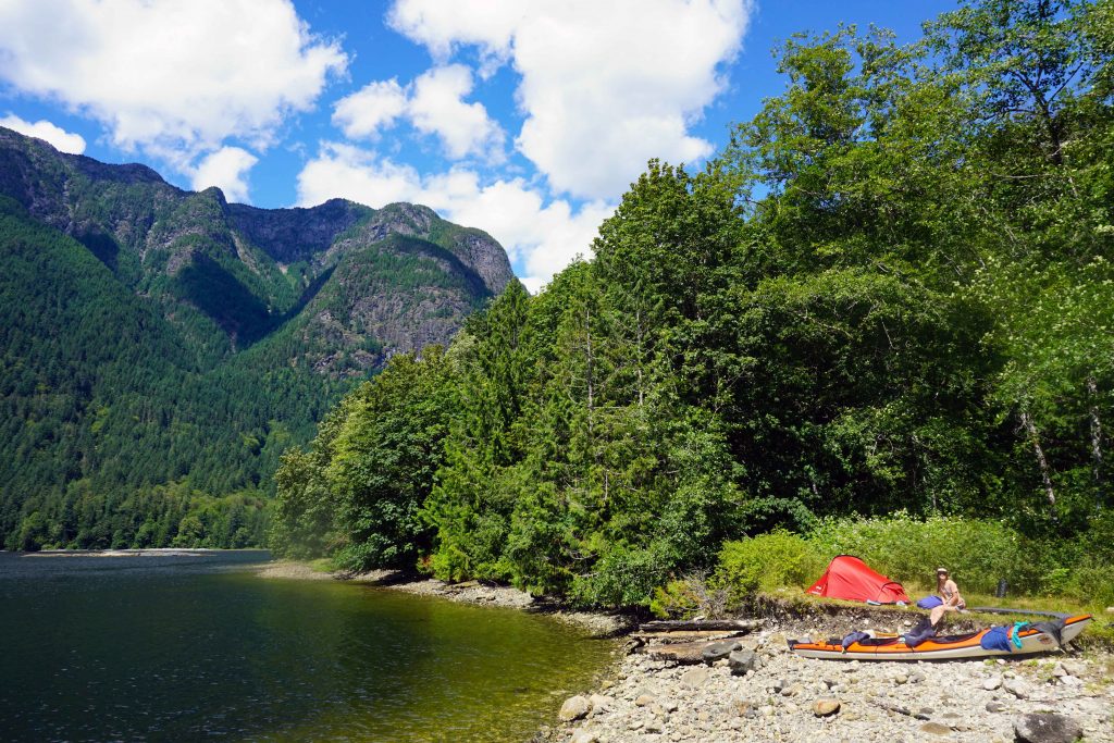 Red tent on the shores of a calm inlet