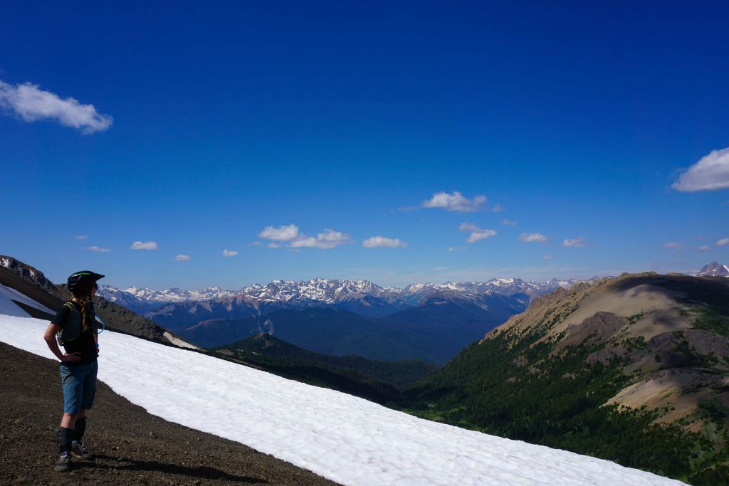 Woman stands on mountain looking across at the view