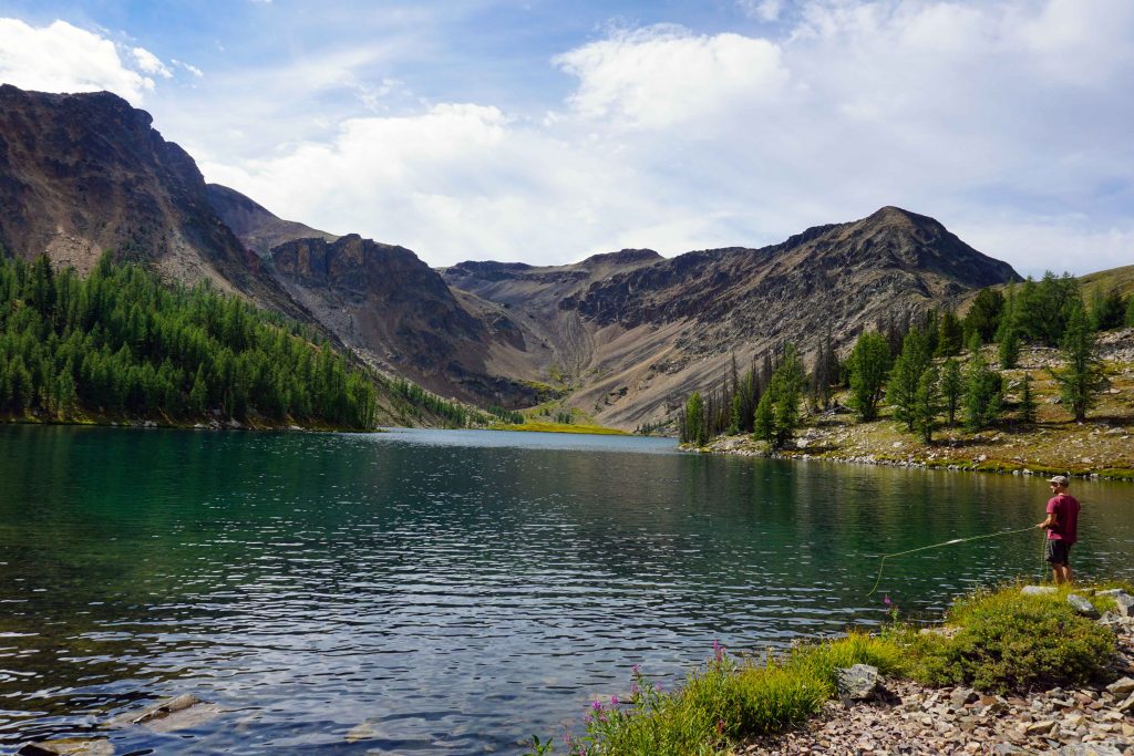 Man fishing at alpine lake