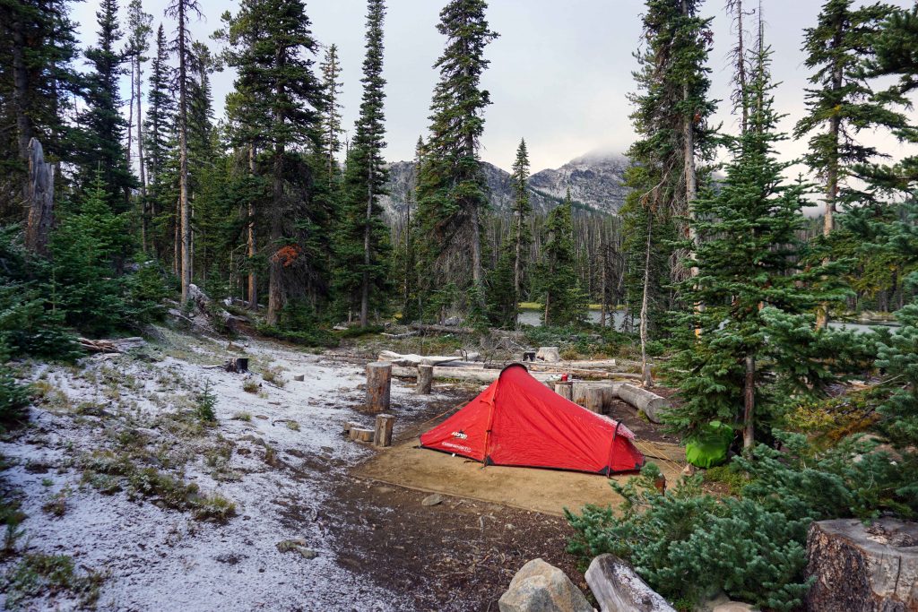 Red tent surrounded by a light dusting of snow